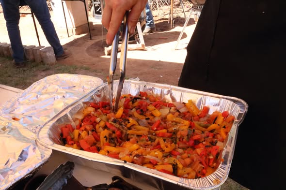 Charola con verduras asadas servida con pinzas