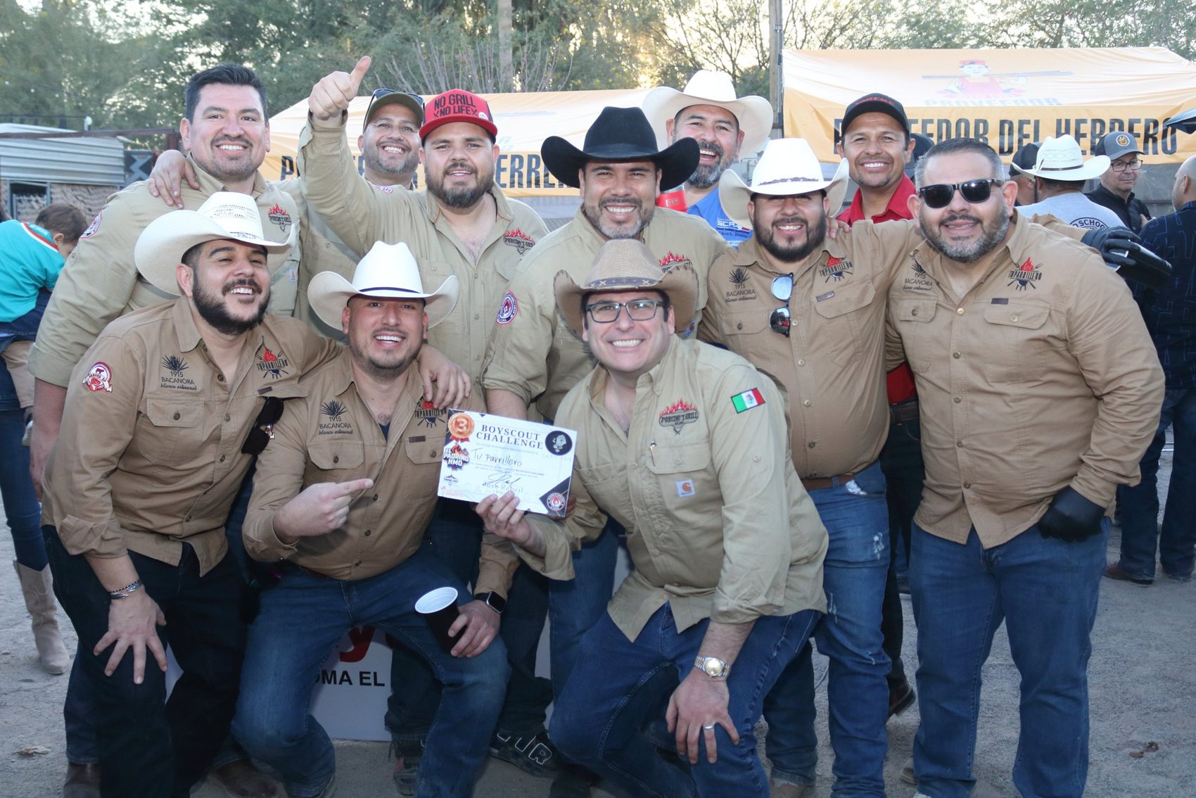 Equipo parrillero con sombreros y camisas iguales posando